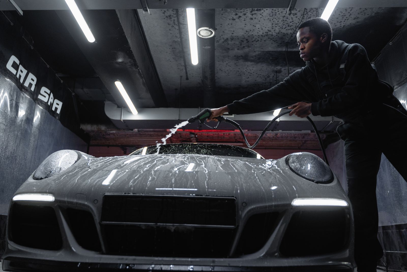 A professional detailer using a pressure washer on a luxury sports car — How much does a full detail cost in Miami Beach? — King Detailing Miami, Miami Beach