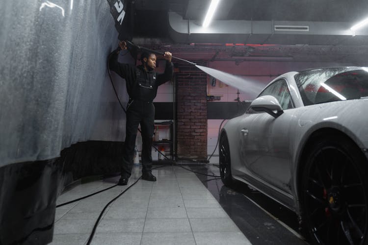 A Man Washing A White Car