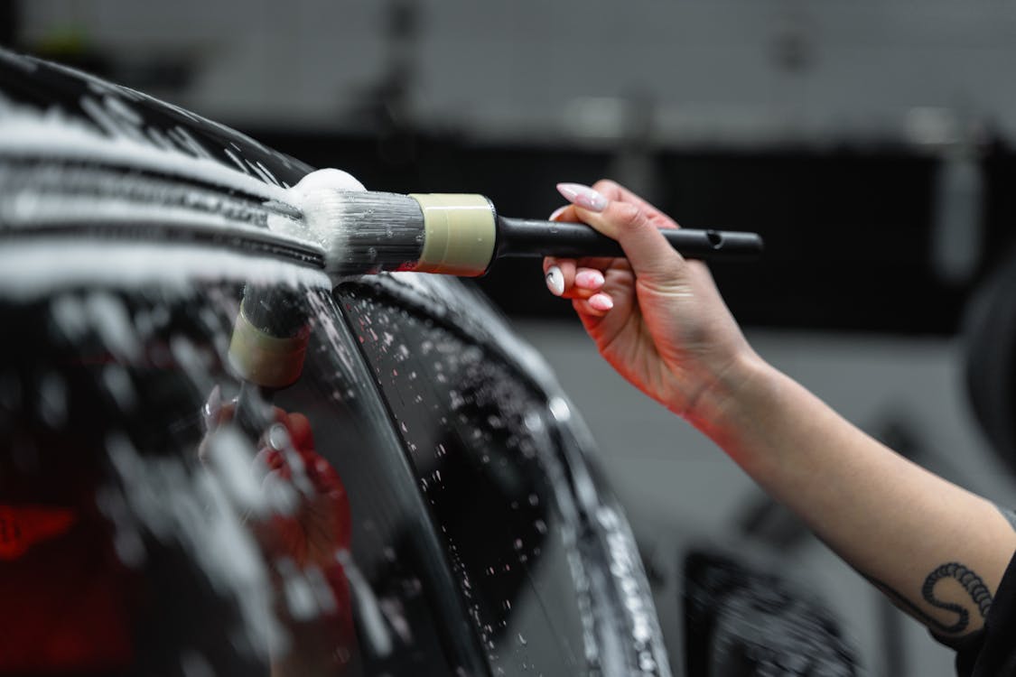 A Close-Up Shot of a Person Brushing a Car · Free Stock Photo