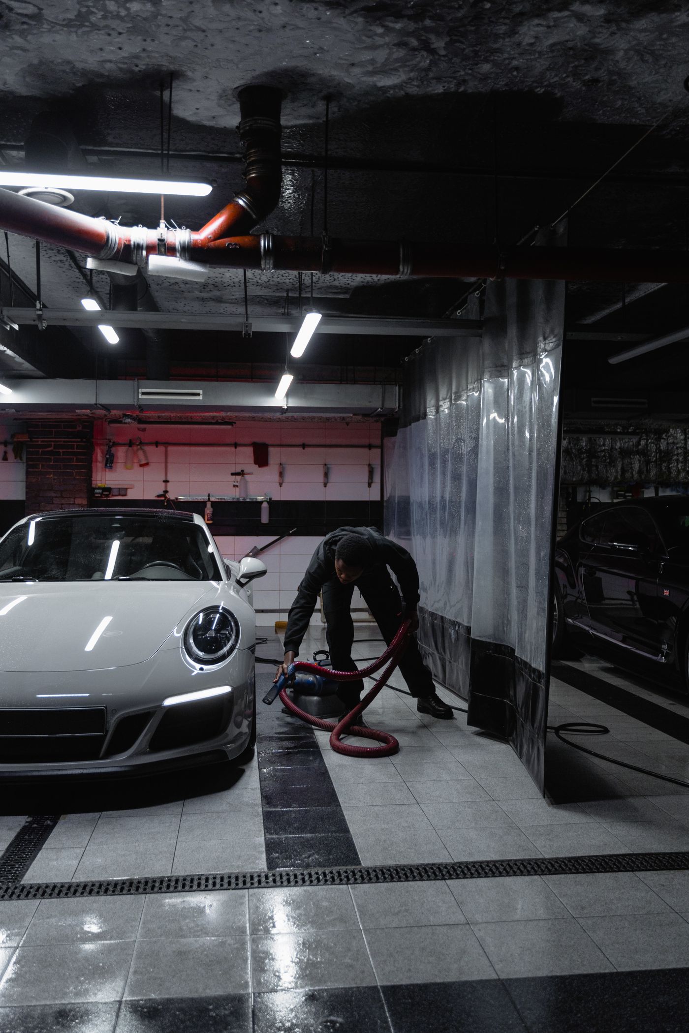 Technicien de MW Motors intervenant sur un véhicule dans une station de lavage