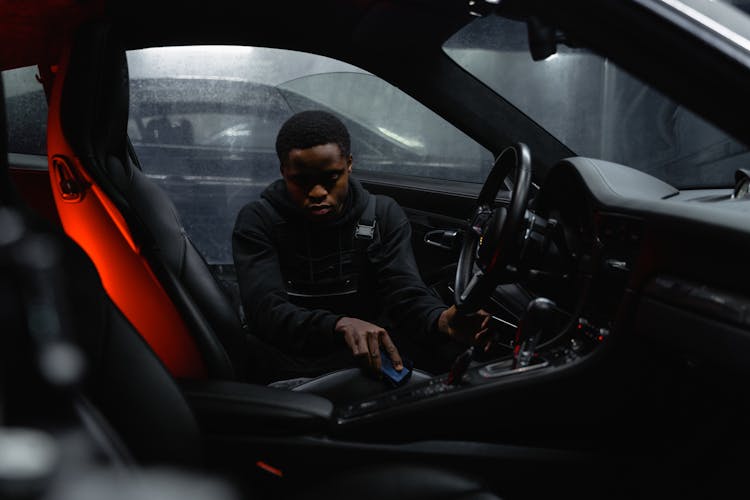 A Man Cleaning The Interior Parts Of The Car