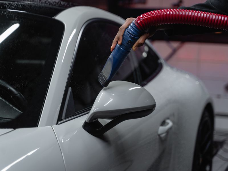 White sports car being vacuumed during interior detailing