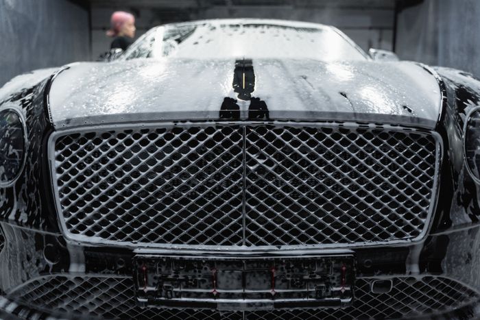 Black car covered in soap before correction