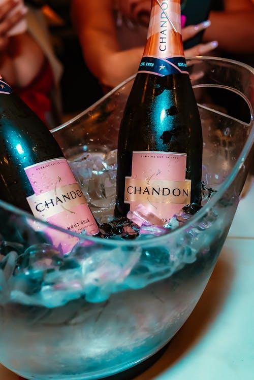 Bottles of Sparkling Wine on a Transparent Bowl with Ice Cubes