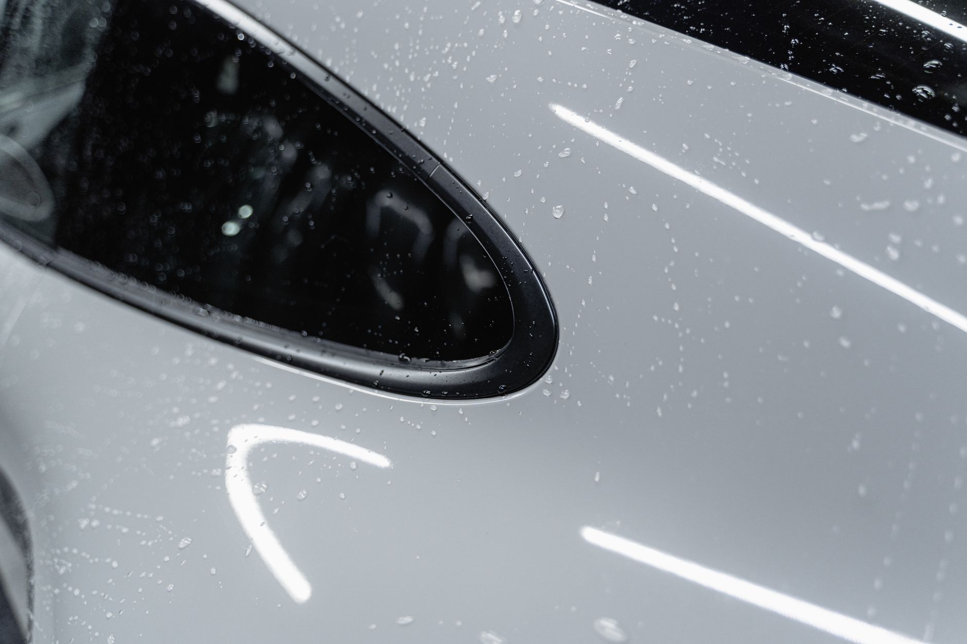 깨끗한 물의 시작: 정수기 설치, 스스로 혹은 전문가와 함께하는 방법 7 A detailed view of a white car with water droplets after a wash, showcasing its shine.