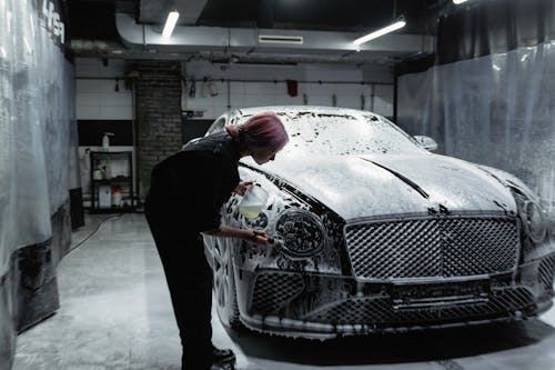 A Woman Washing a Luxury Car