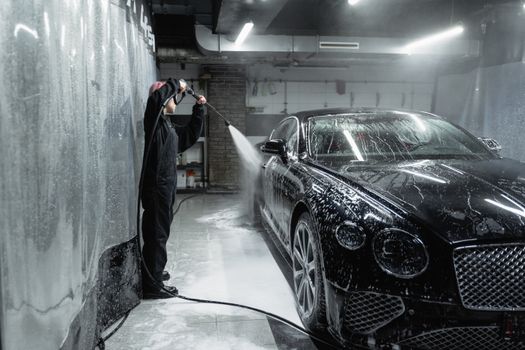 Man in Black Jacket Standing Beside Black Bmw M 3