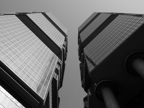 From below black and white of contemporary symmetric twin tower skyscraper complex with glass mirrored facades located in Hong Kong on sunny day