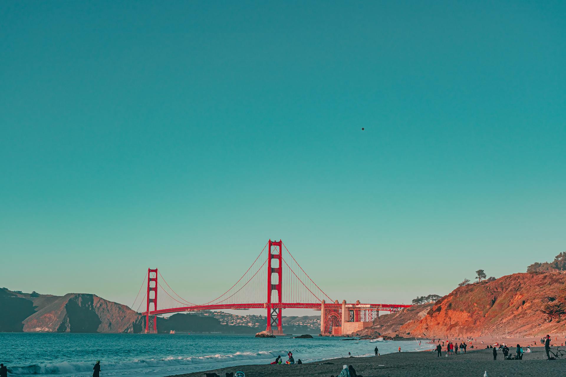 Scenic view of the Golden Gate Bridge framed by the beach in San Francisco under a clear sky.