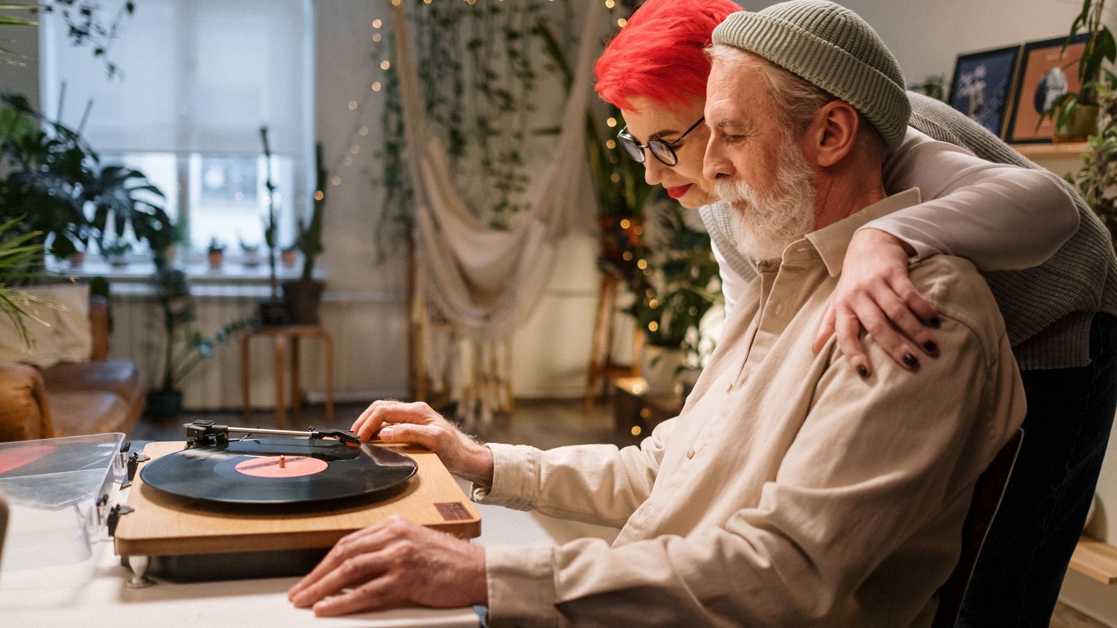 Two adults listening to a vinyl record at home