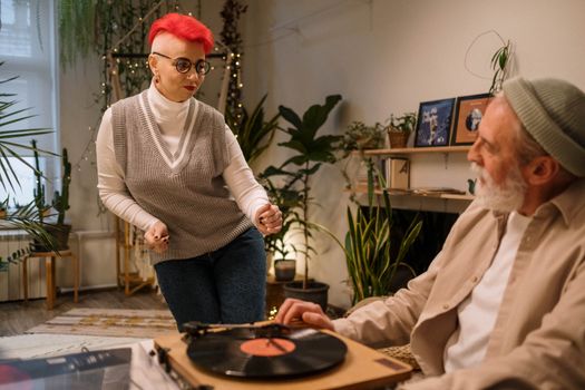An Elderly Woman Dancing while the Other Man is Operating the Turntable
