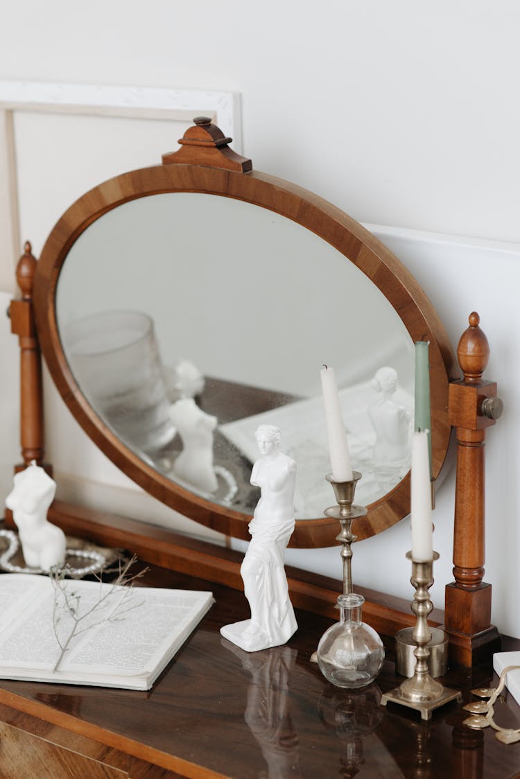 Figurine Candles In Front Of A Mirror