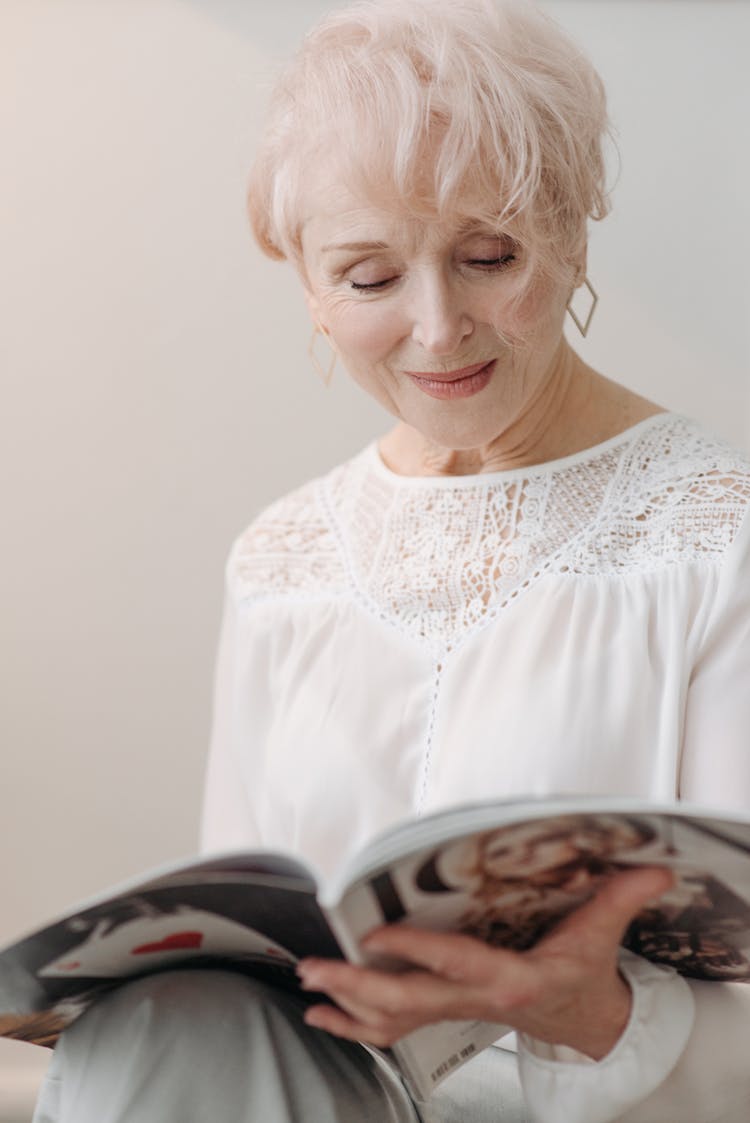 Photo Of An Elderly Woman Reading A Magazine