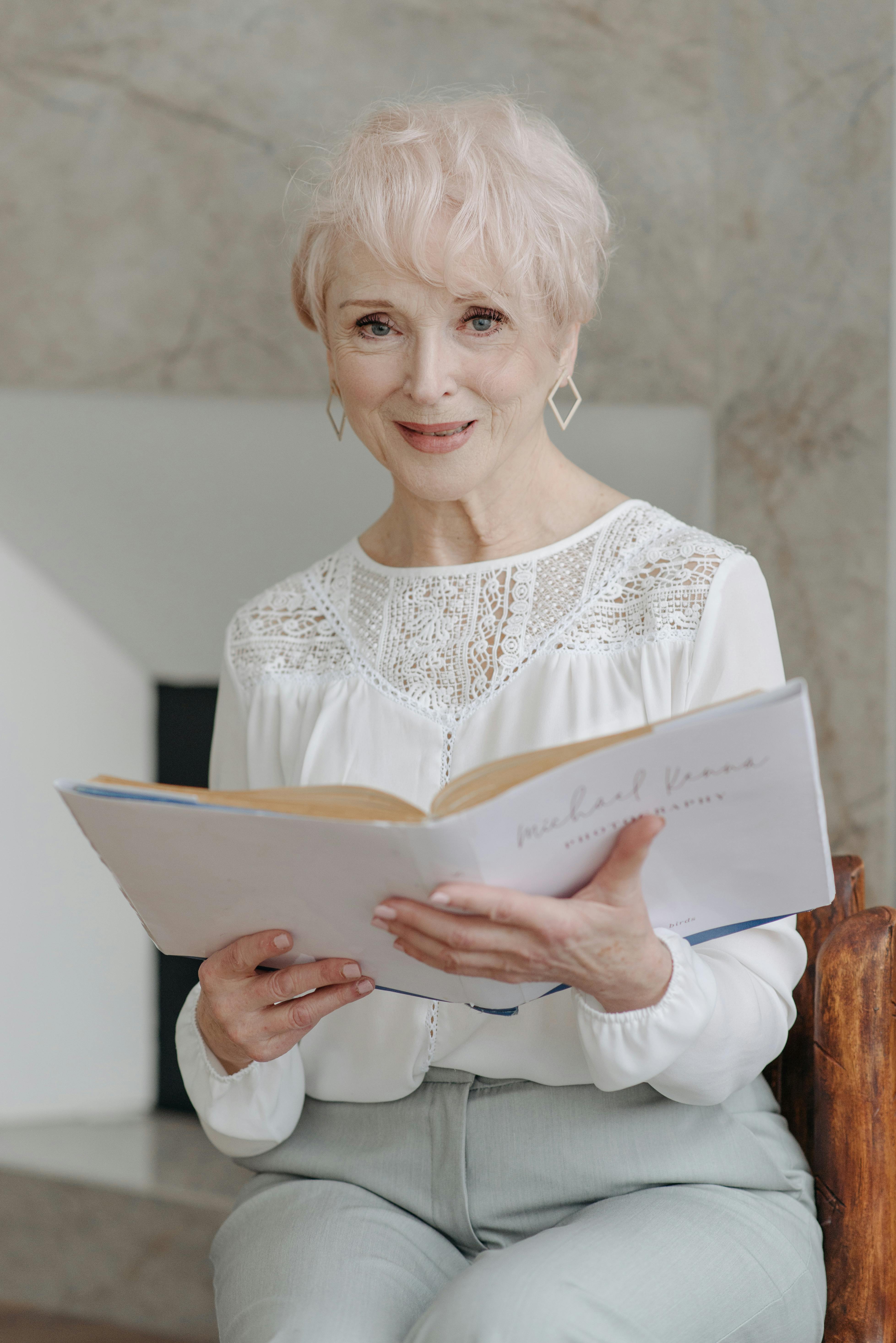 photo of a woman in a white blouse holding a white book