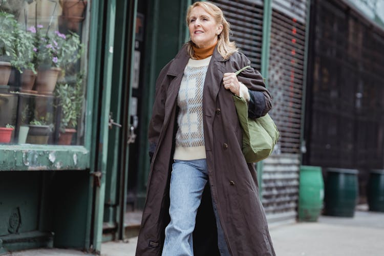 Confident Mature Woman Strolling On Walkway In City