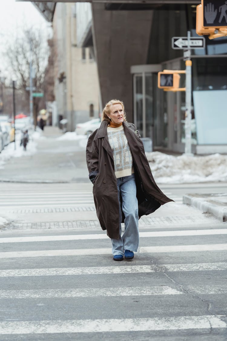 Elderly Woman In Coat Crossing Road In Town