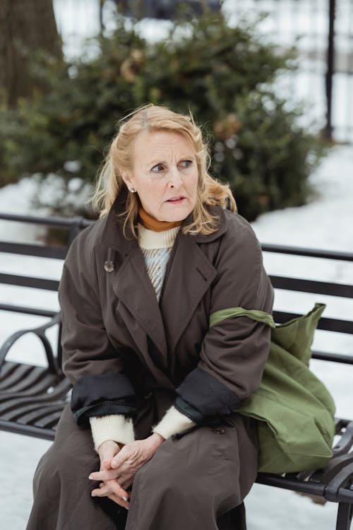 Afraid woman on urban bench in winter