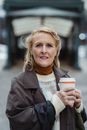 Senior woman with takeaway coffee on city street