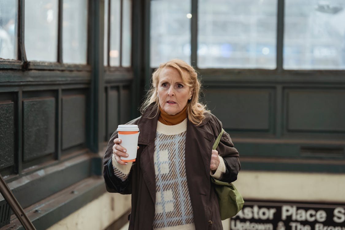 Scared woman with coffee to go in building