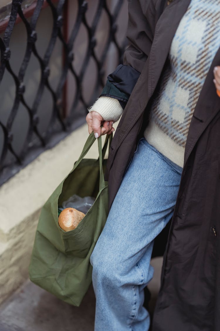 Crop Woman With Bread In Bag Walking On Street