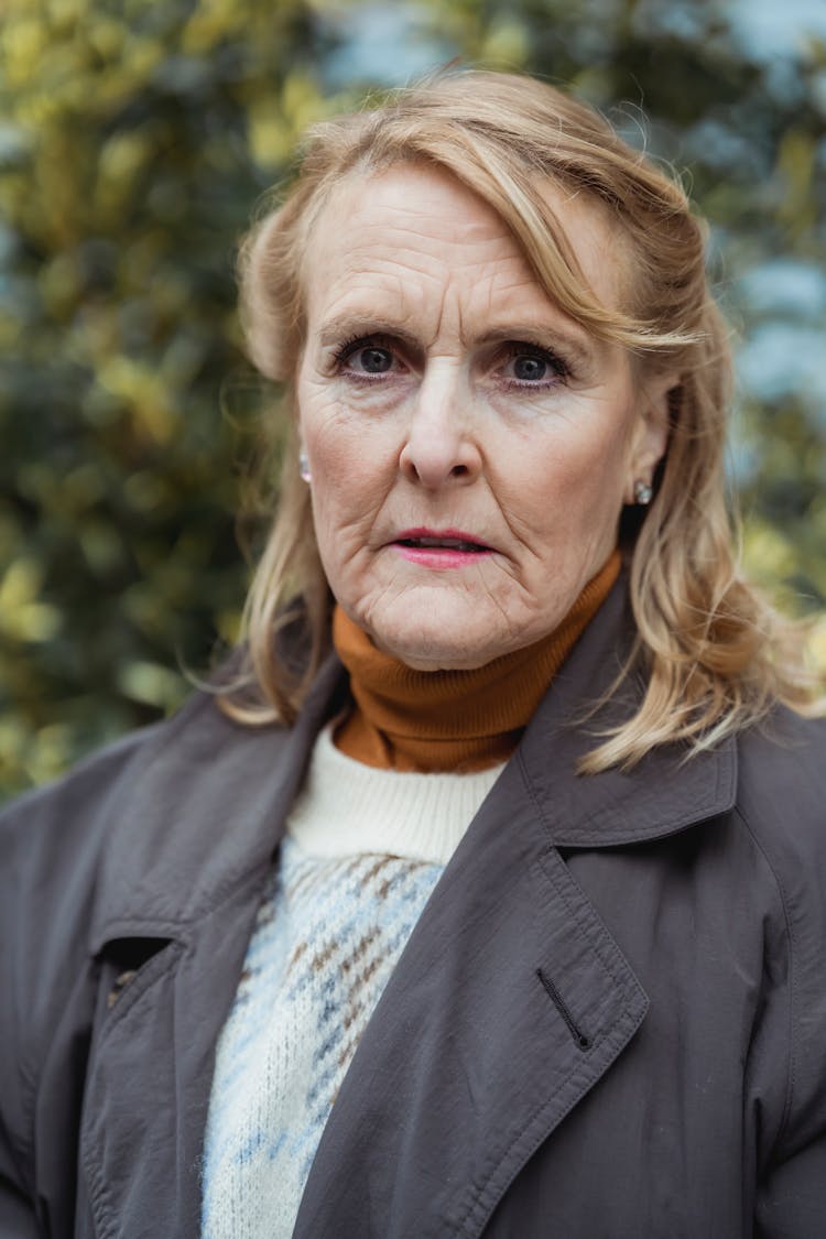 Serious Elderly Woman In Outerwear In Park