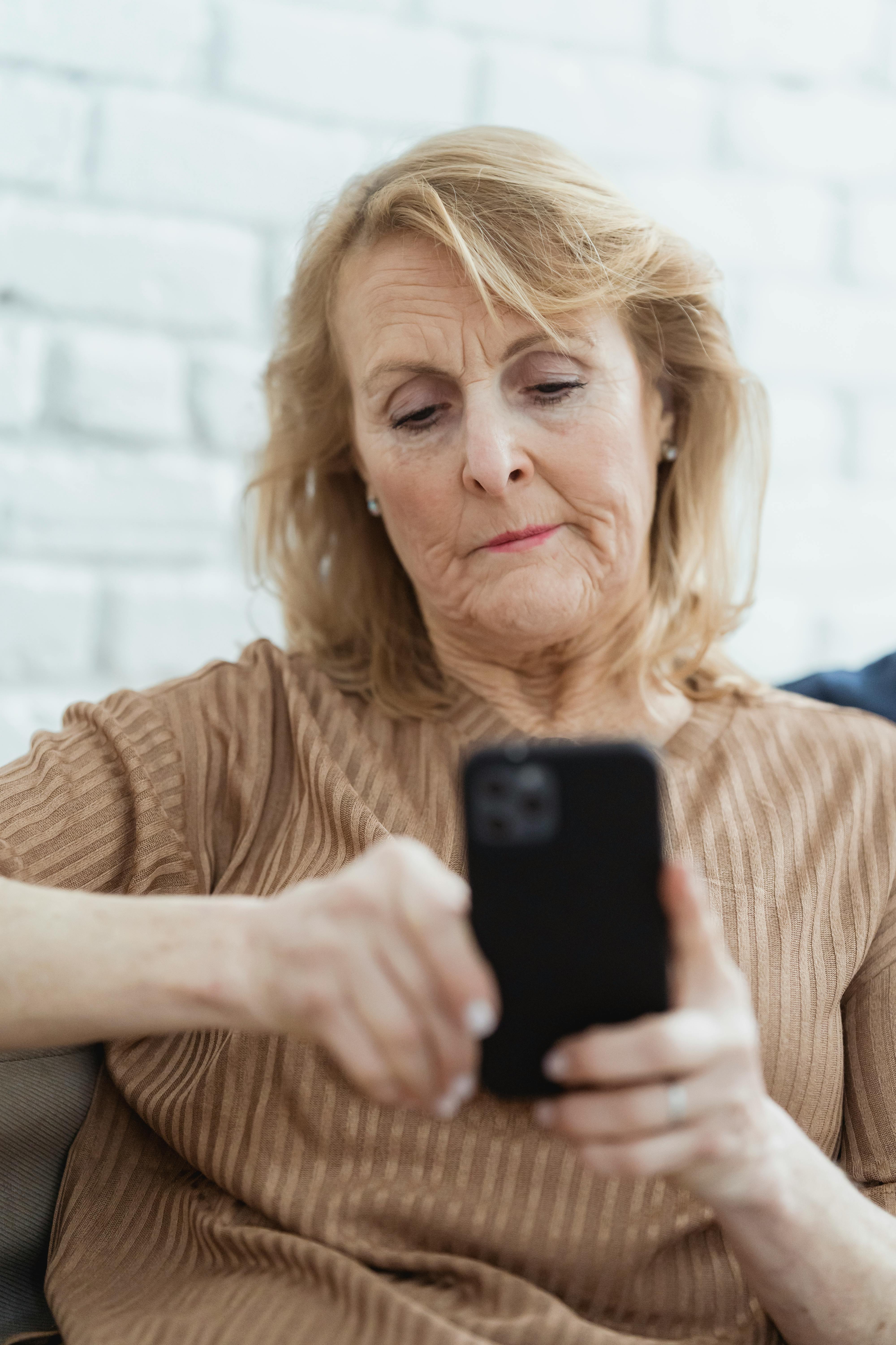 senior woman surfing internet on smartphone at home