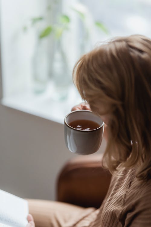 Anonymous woman drinking tea in morning