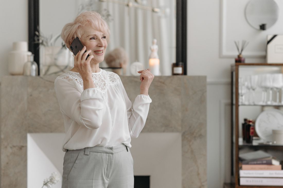 An older patient smiling during a phone call at home