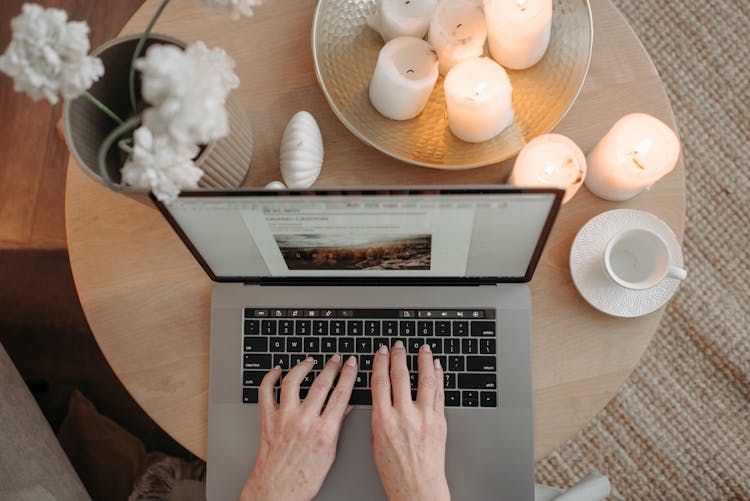 A Person Typing On A Laptop