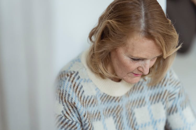 Relaxed Mature Woman Looking Down At Home