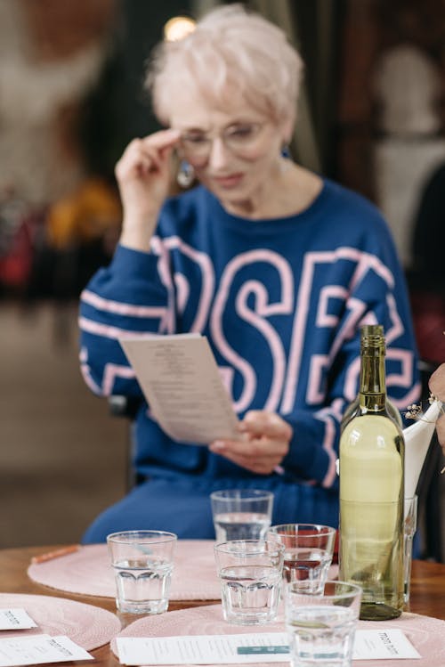 Senior Woman Reading a Menu in a Restaurant