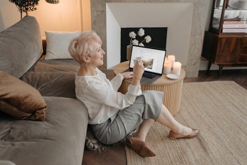 A Short Haired Woman Using a Laptop while Drinking Tea