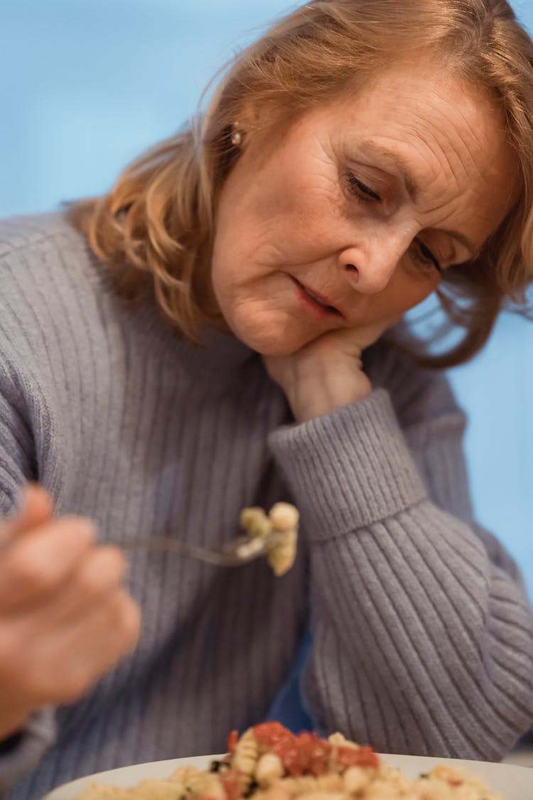 Crop Mature Unemotional Woman Eating Freshly Cooked Pasta