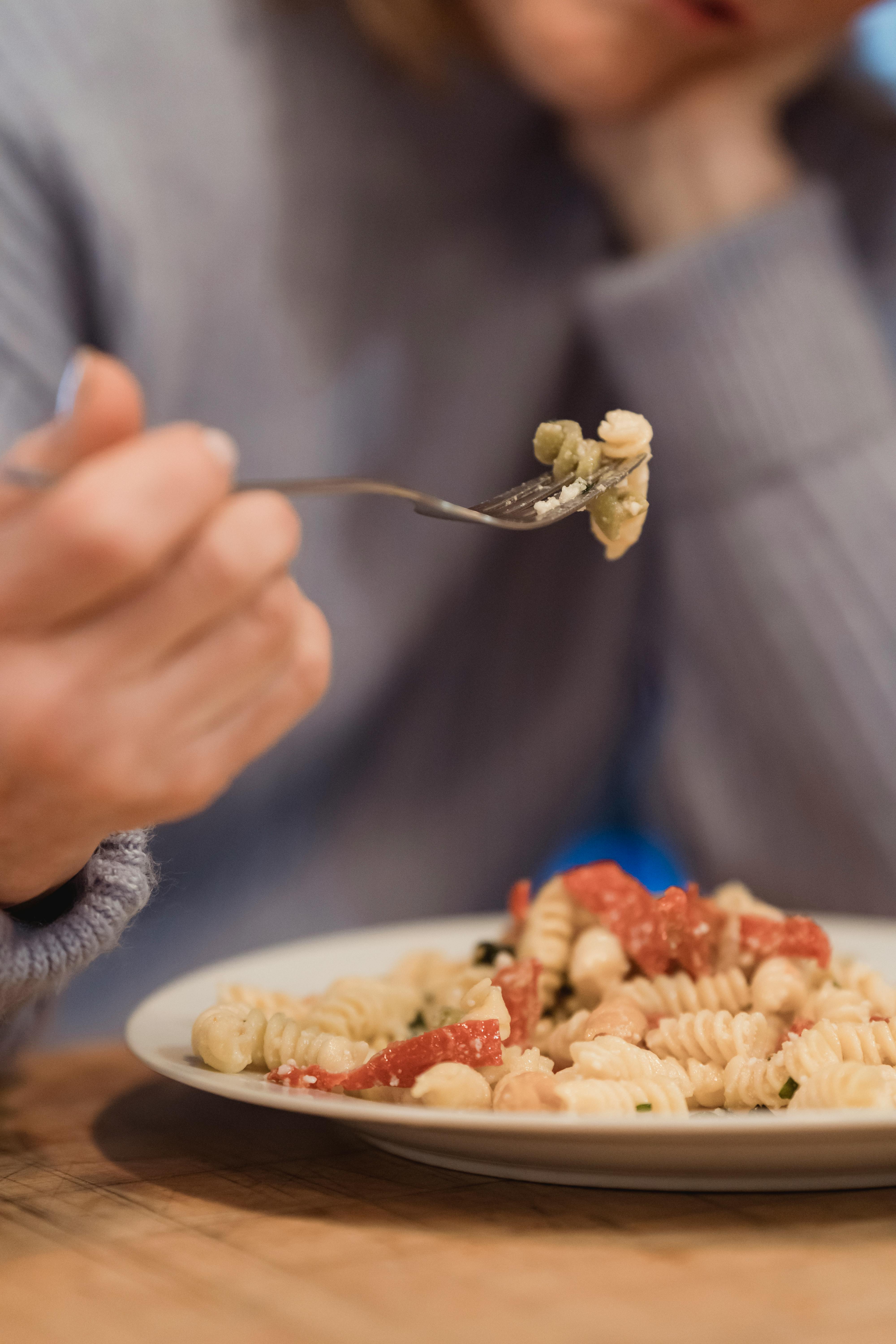 crop unrecognizable woman eating delicious pasta