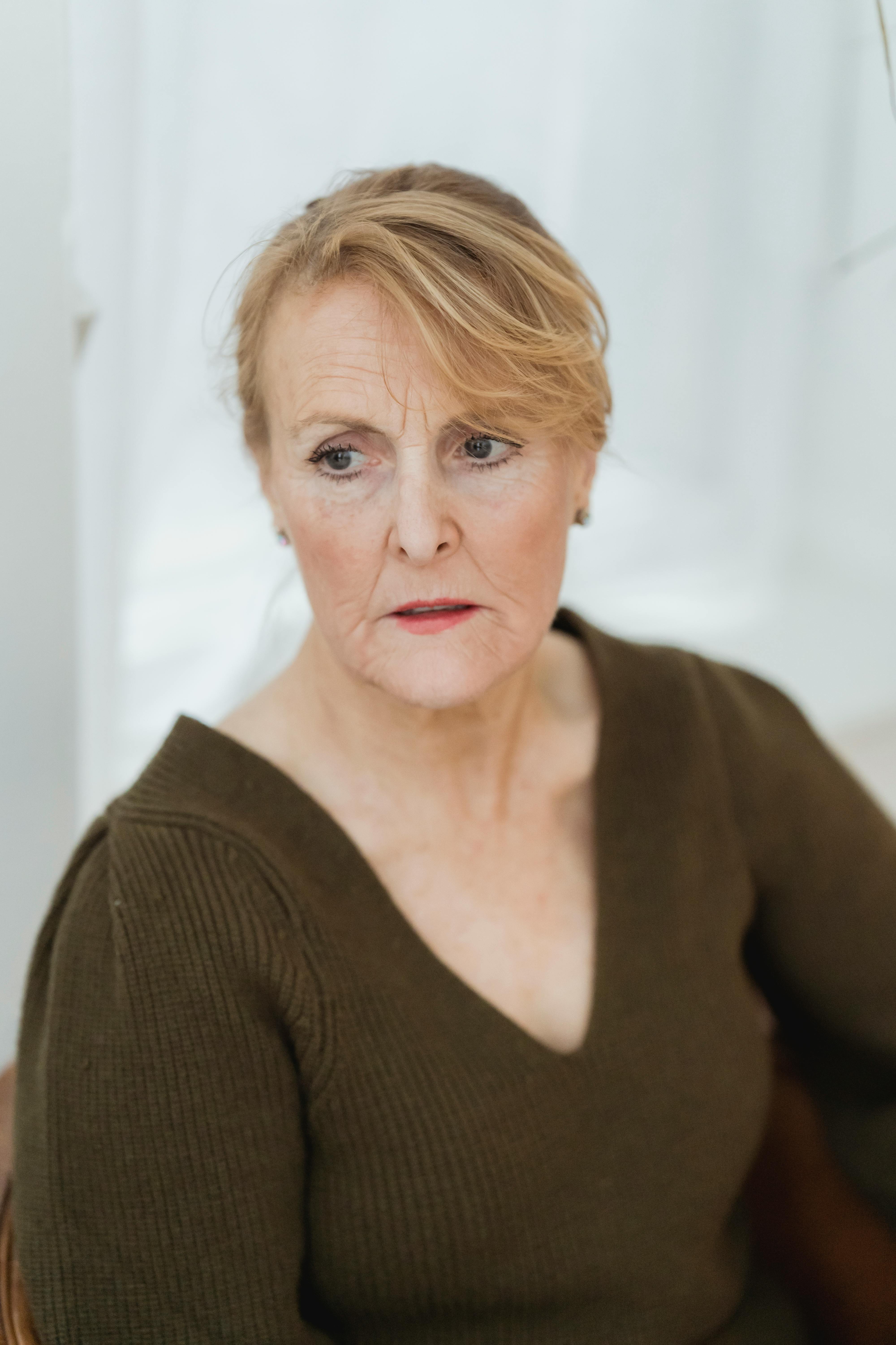 contemplative senior woman sitting in light room