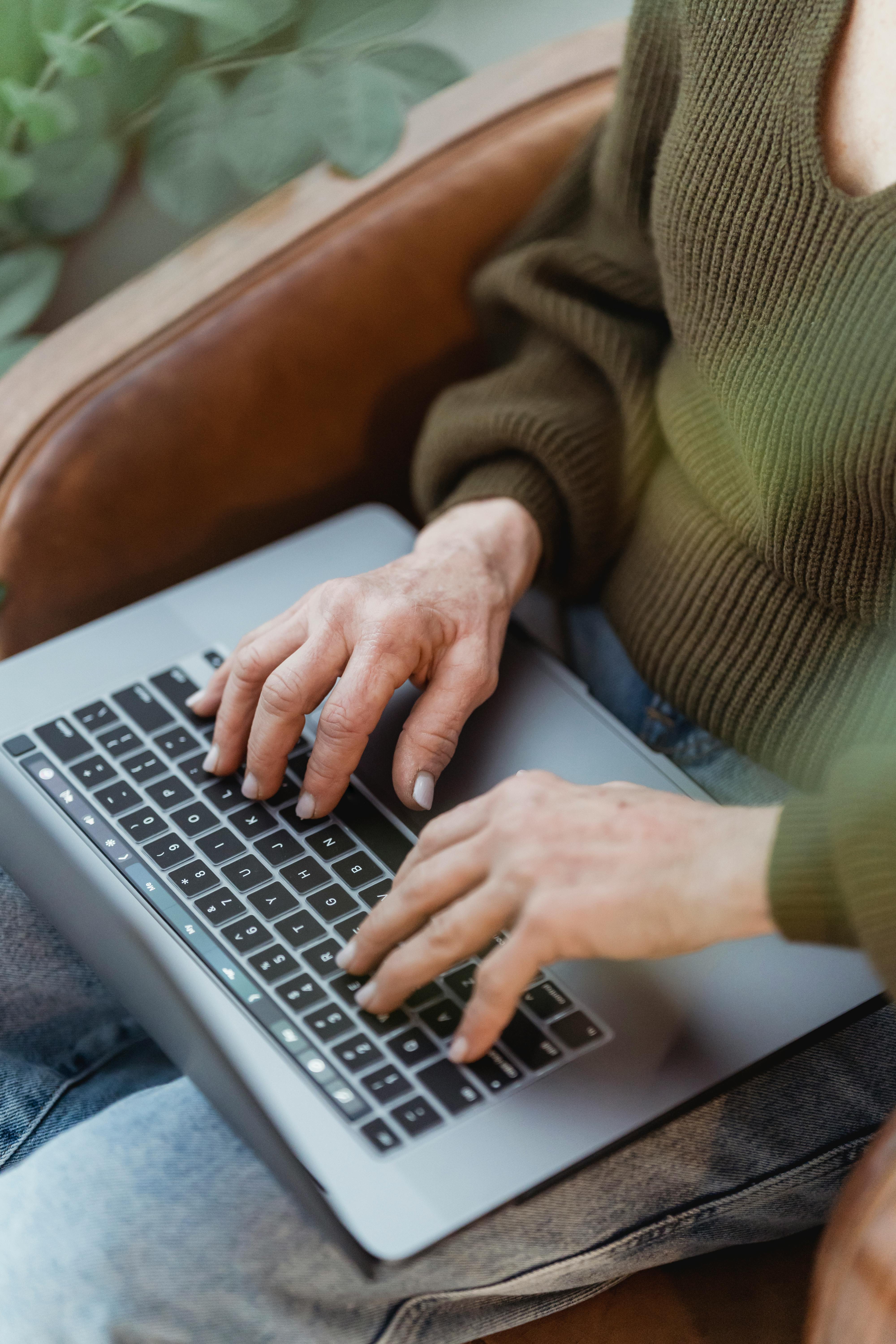 crop faceless woman typing on laptop