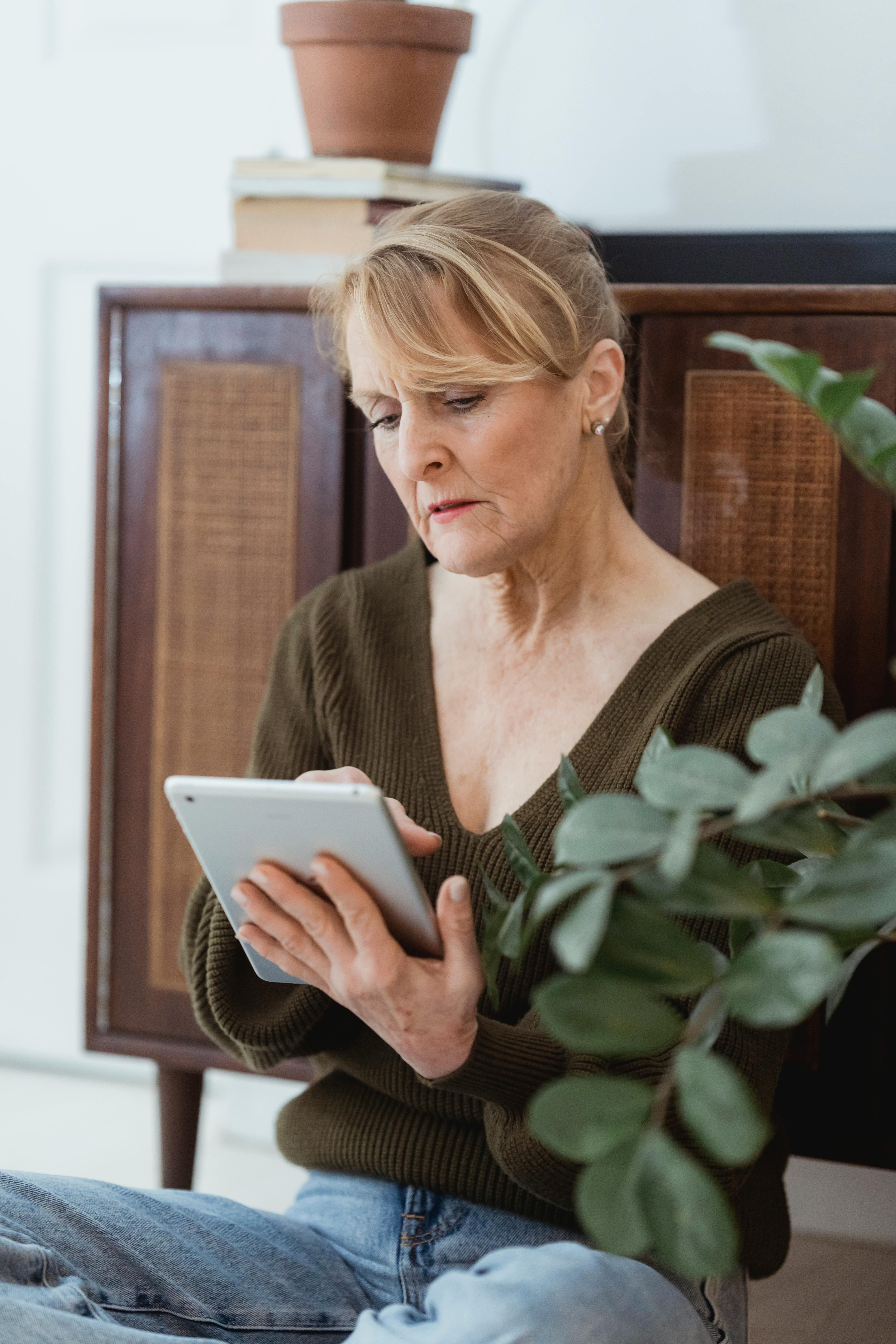 mature woman surfing internet on smartphone at home