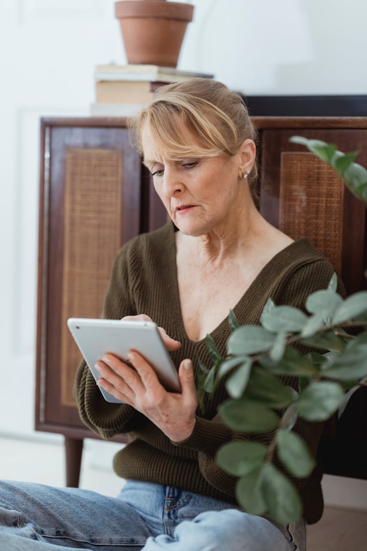 Mature Woman Surfing Internet On Smartphone At Home