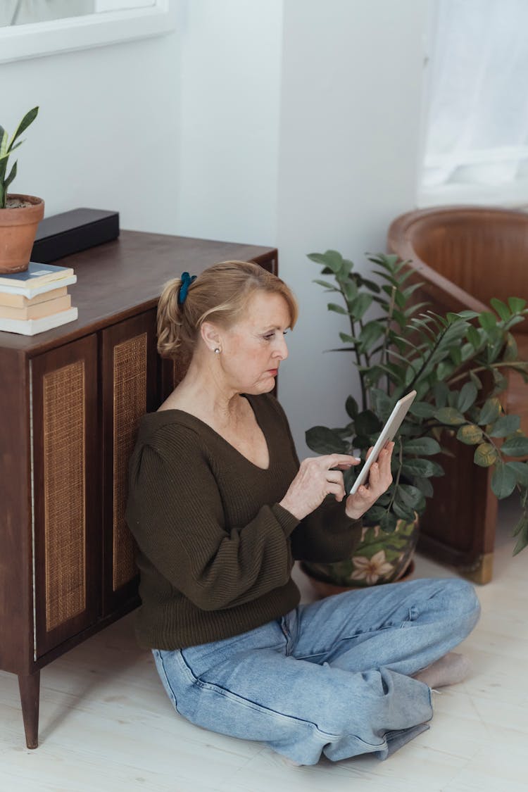 Mature Woman Browsing Internet On Smartphone At Home