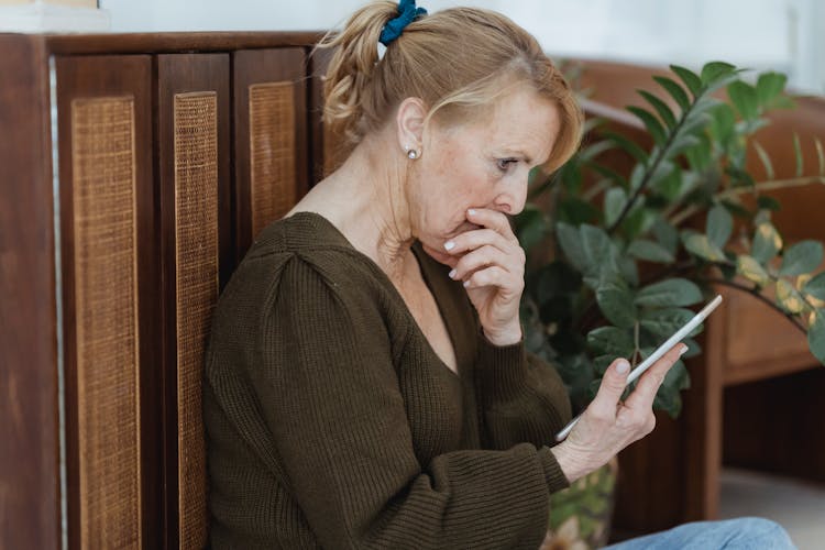 Amazed Senior Woman With Smartphone In House Room