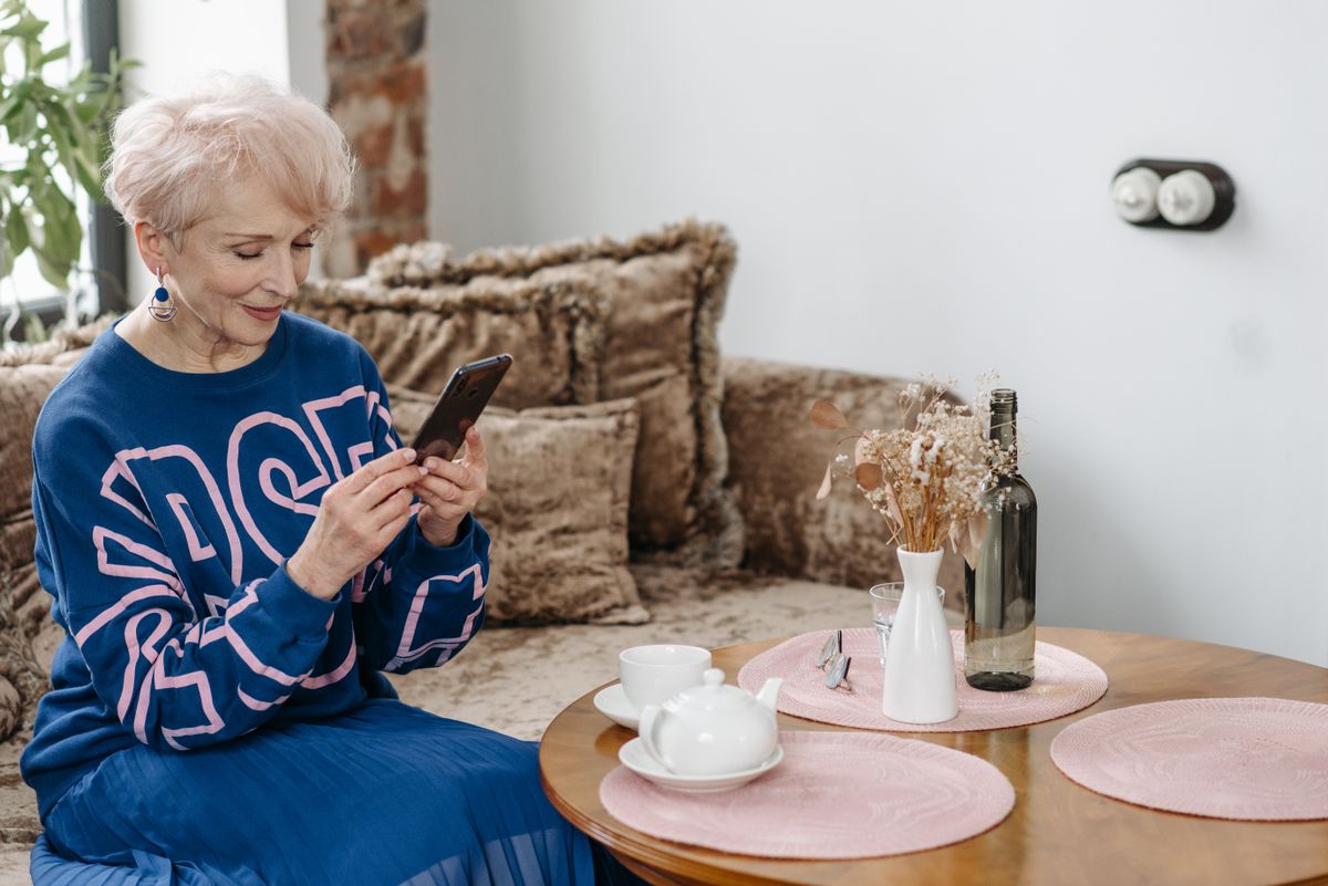 Donna che guarda le fotografie sul telefono; fotografia illustrativa
