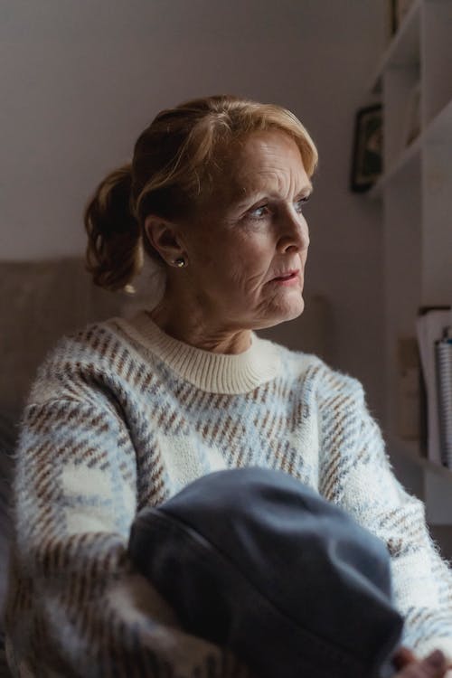 Wistful woman in sweater resting at home