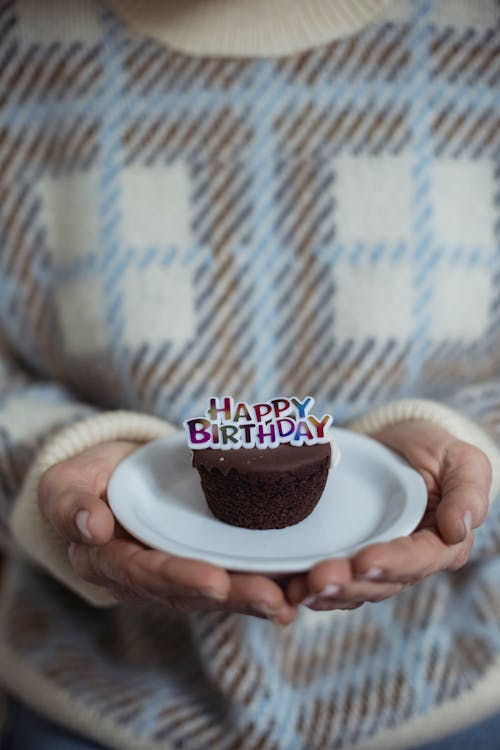 上に誕生日の装飾が施されたチョコレートカップケーキ