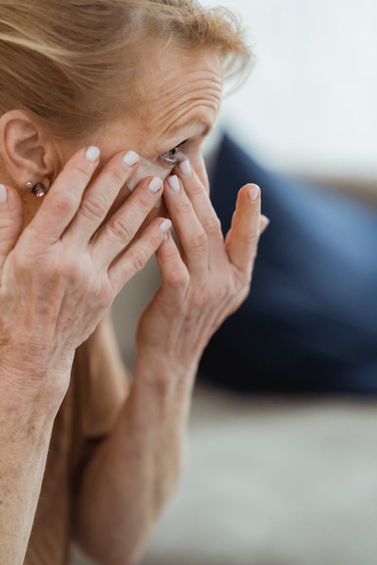 Crop Mature Woman Applying Eye Patches