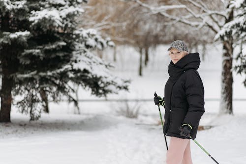 A Woman in a Black Jacket Holding Trekking Poles