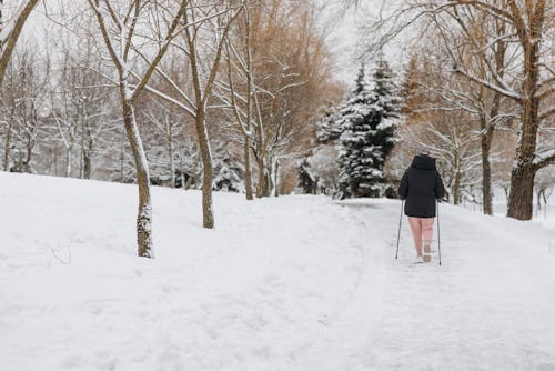 Woman Walking on Snow Covered Path