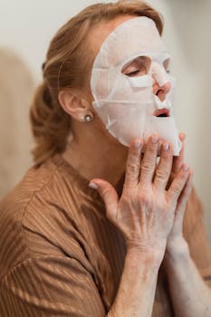 Senior woman with cosmetic face mask relaxing indoors. Perfect for skincare and self-care concepts.