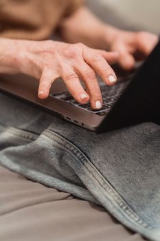 A close-up of adult hands typing on a laptop keyboard, symbolizing productivity and remote work.