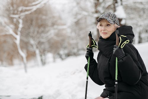 A Woman Holding Trekking Poles while Sitting