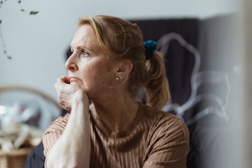Free Senior woman with a thoughtful expression looking away in an indoor setting. Stock Photo
